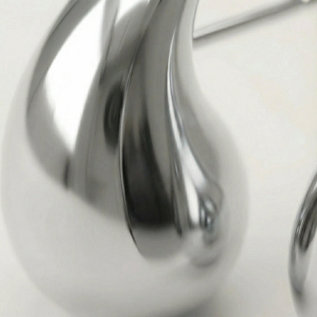 Close-up orecchini Goccia Essenza placcati argento con dettaglio del volume