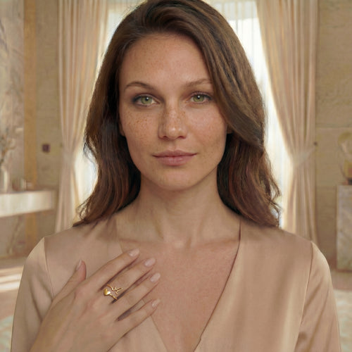 Modella che indossa anello con iniziale e cuore su struttura aperta in finitura oro