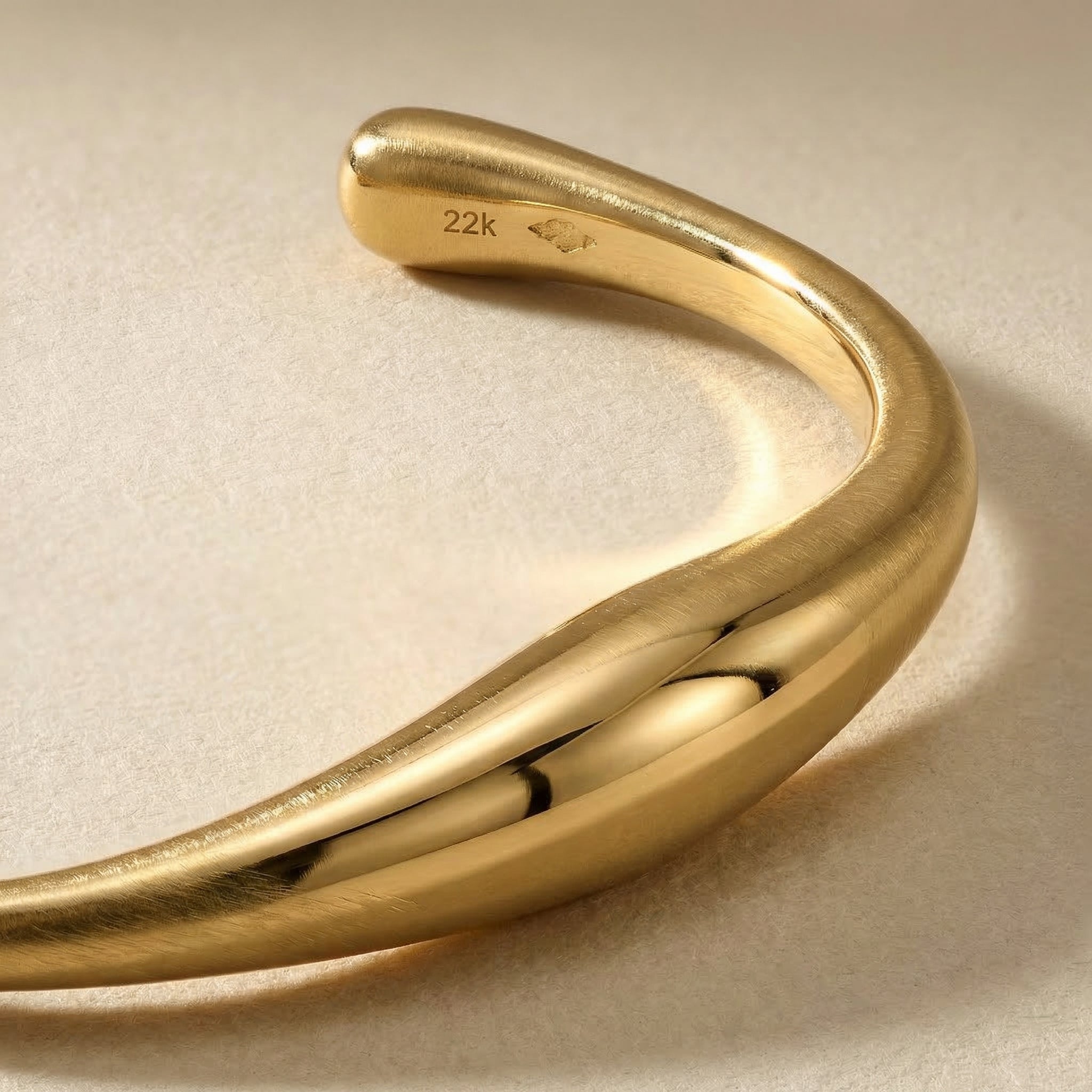 Dettaglio ravvicinato del bracciale con linea organica e struttura aperta in finitura oro