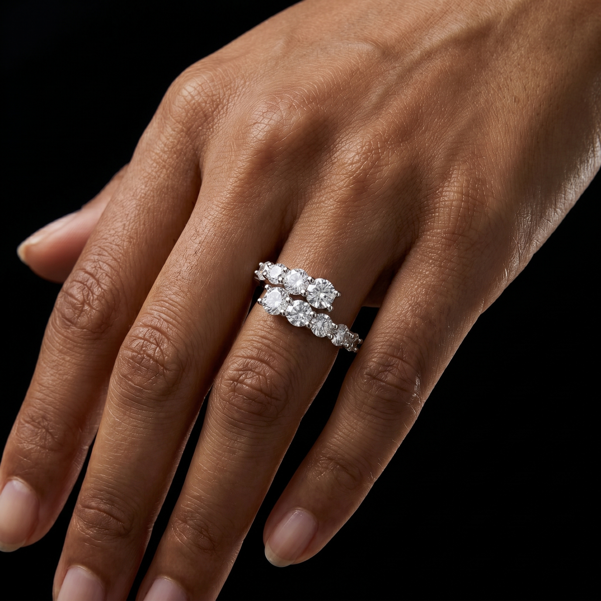 Close up su modella con anello in argento con composizione luminosa di zirconi